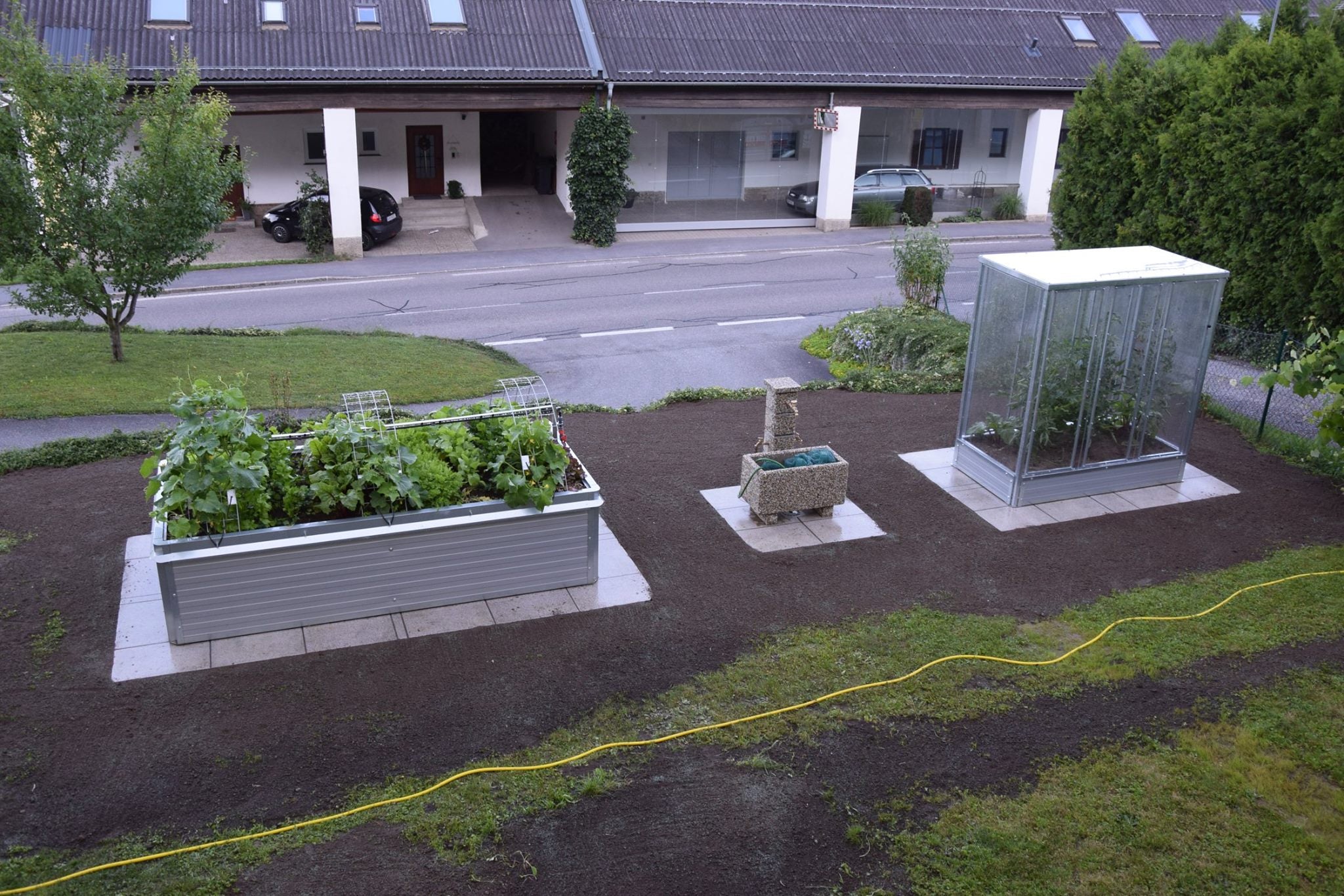 Verschiedene Hochbeete & Tomatenhaus im Garten.